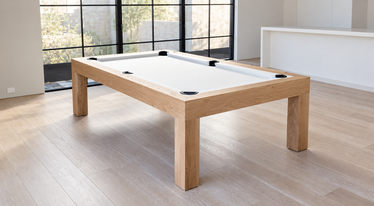 Modern Natural White Oak Rift Pool Table with white felt, square legs, and black pockets beside large windows.